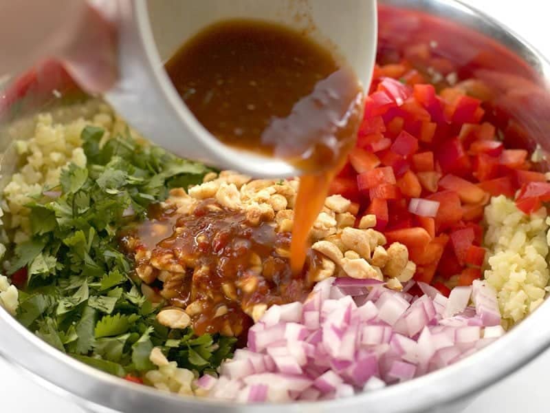 Lime dressing being poured over the salad