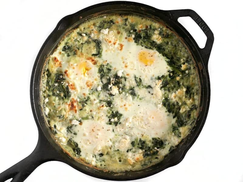 Finished Creamed Spinach with baked eggs in cast iron skillet