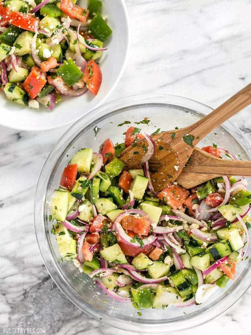 Super Fresh Cucumber Salad being served into smaller bowls with wooden spoons