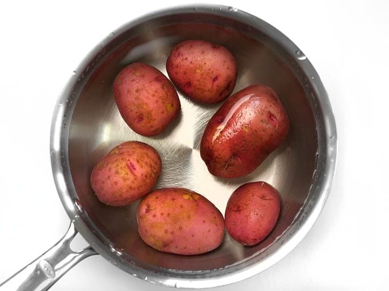 Red potatoes in a sauce pot covered with water