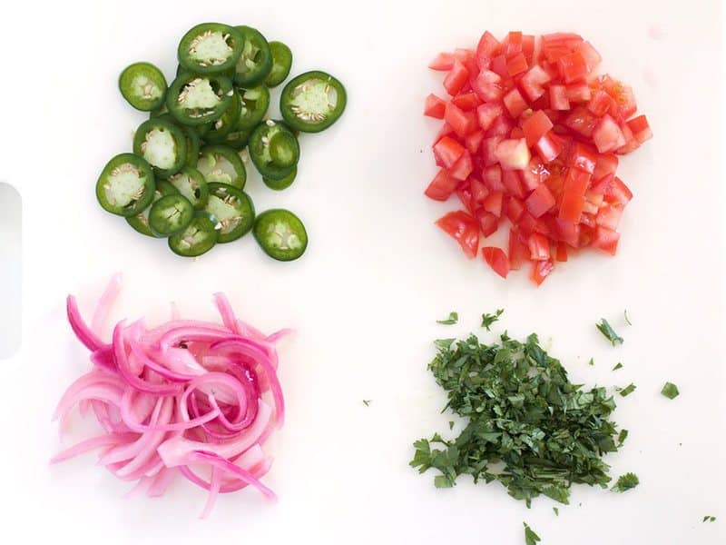 Cold Toppings for baked nachos - jalapenos, pickled onions, diced fresh tomato, and cilantro