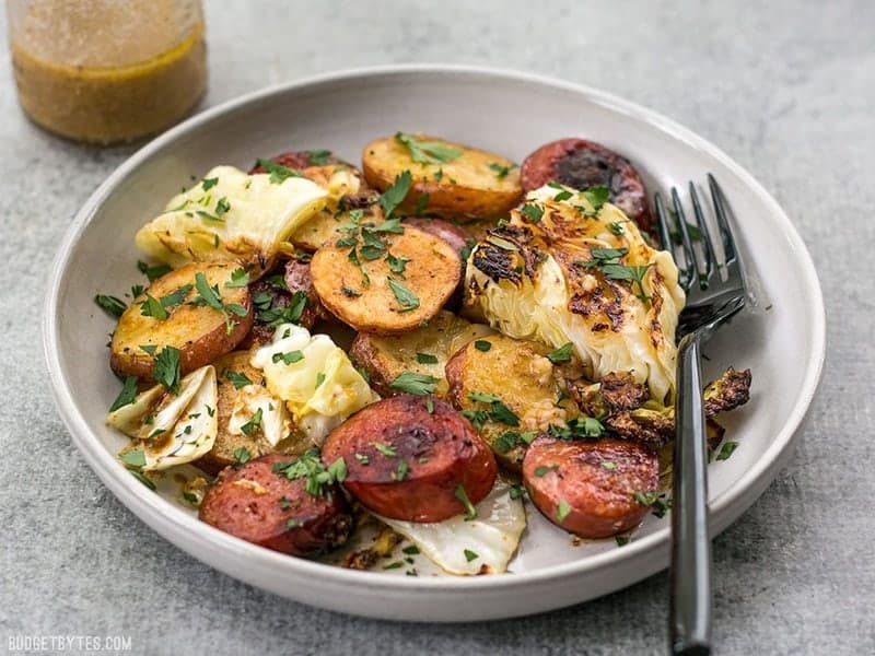 A plate full of One Pan Roasted Kielbasa and Cabbage Dinner ready to be eaten