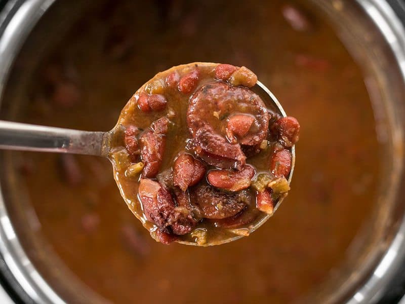 Close up ladle full of Pressure Cooker Red Beans overhead.