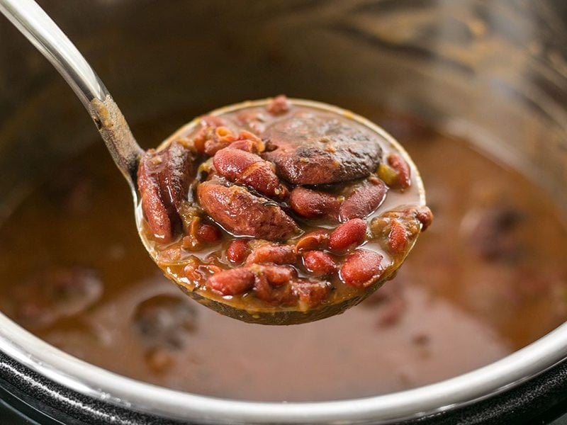 A ladle lifting a scoop of Pressure Cooker Red Beans out of the Instant Pot