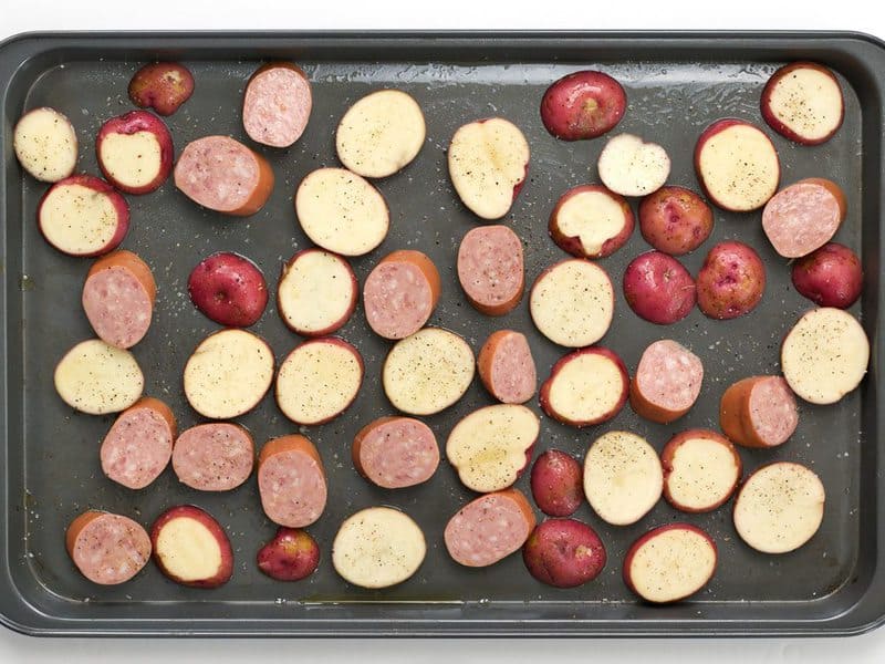 Sliced Potatoes and Kielbasa on a baking sheet