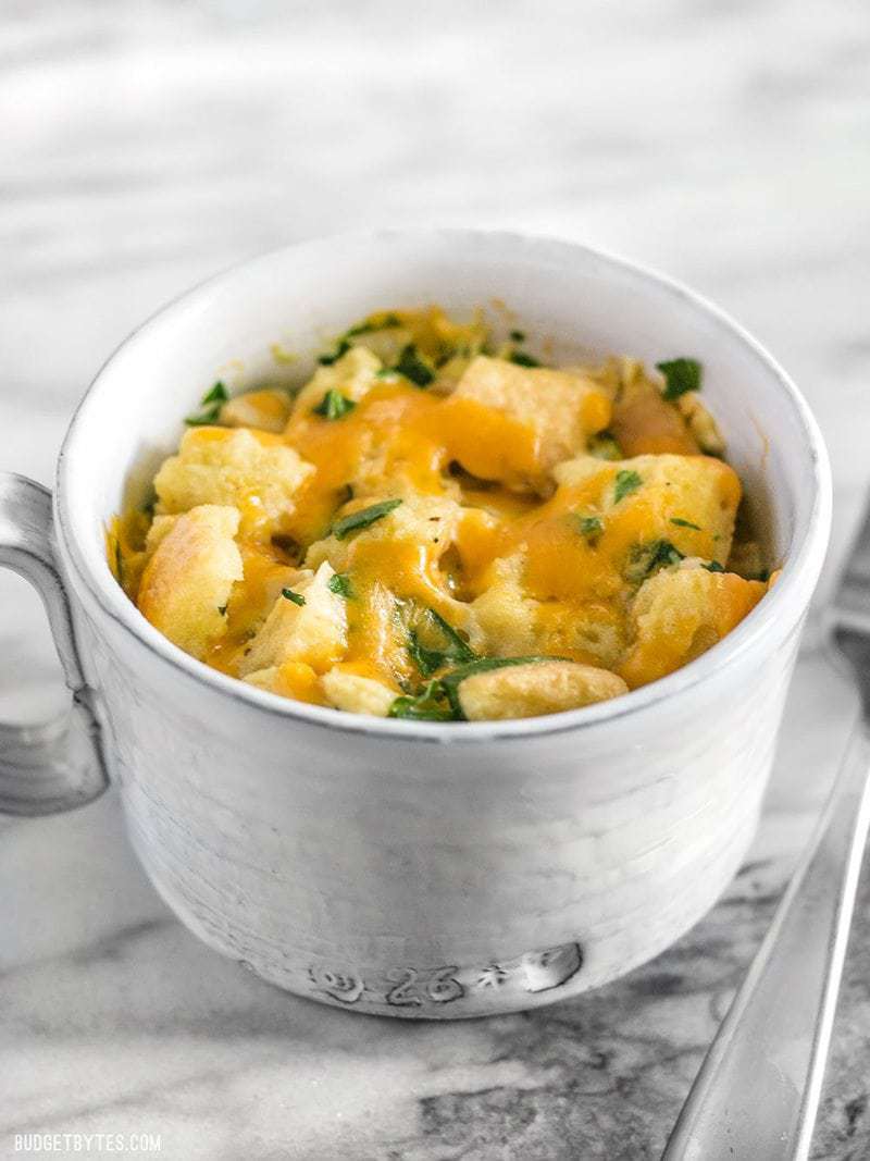 A savory breakfast mug from the front, melted cheese and parsley on top