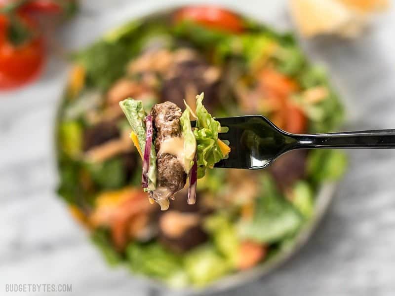 When you're got to have your burger, but you're trying to do better, make a Cheeseburger Salad! BudgetBytes.com Close up of a forkful of Cheeseburger Salad with animal sauce dressing