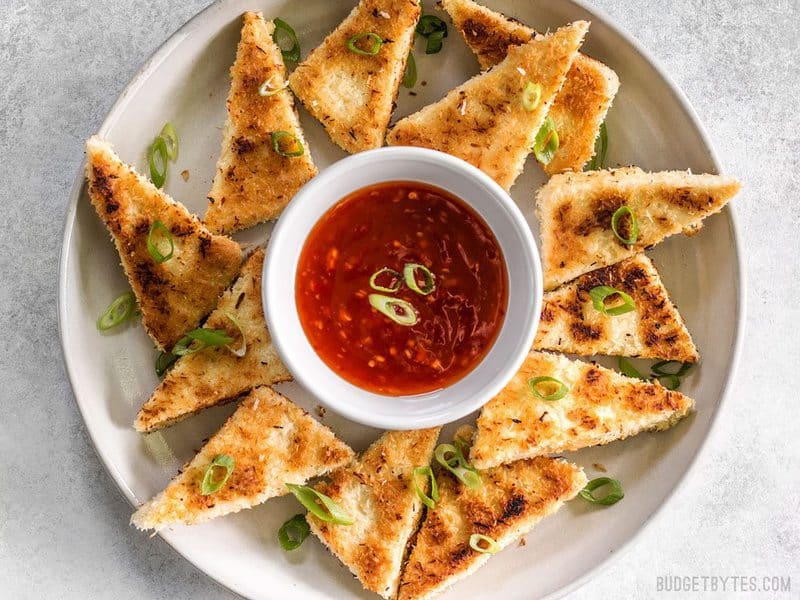 A plate full of Coconut Crusted Tofu dippers with a bowl of sweet chili sauce in the center