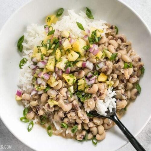 These rich and spicy Coconut Jerk Peas are super simple to make and pair brilliantly with a sweet and vibrant pineapple salsa. BudgetBytes.com