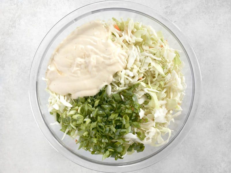 Kohl-Frühlingszwiebeln und Krautsalat-Dressing in einer Schüssel