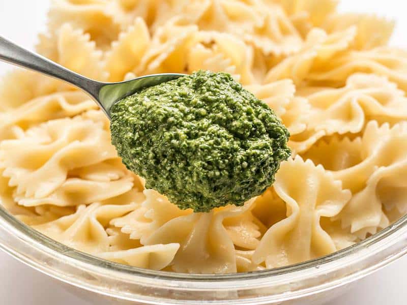 Spoon kale pesto onto cooked pasta