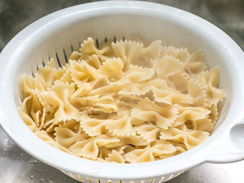 Cooked and drained bowtie pasta in the colander