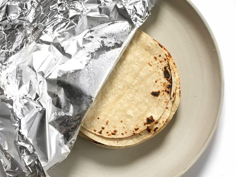 Toasted Corn Tortillas on a plate covered in foil