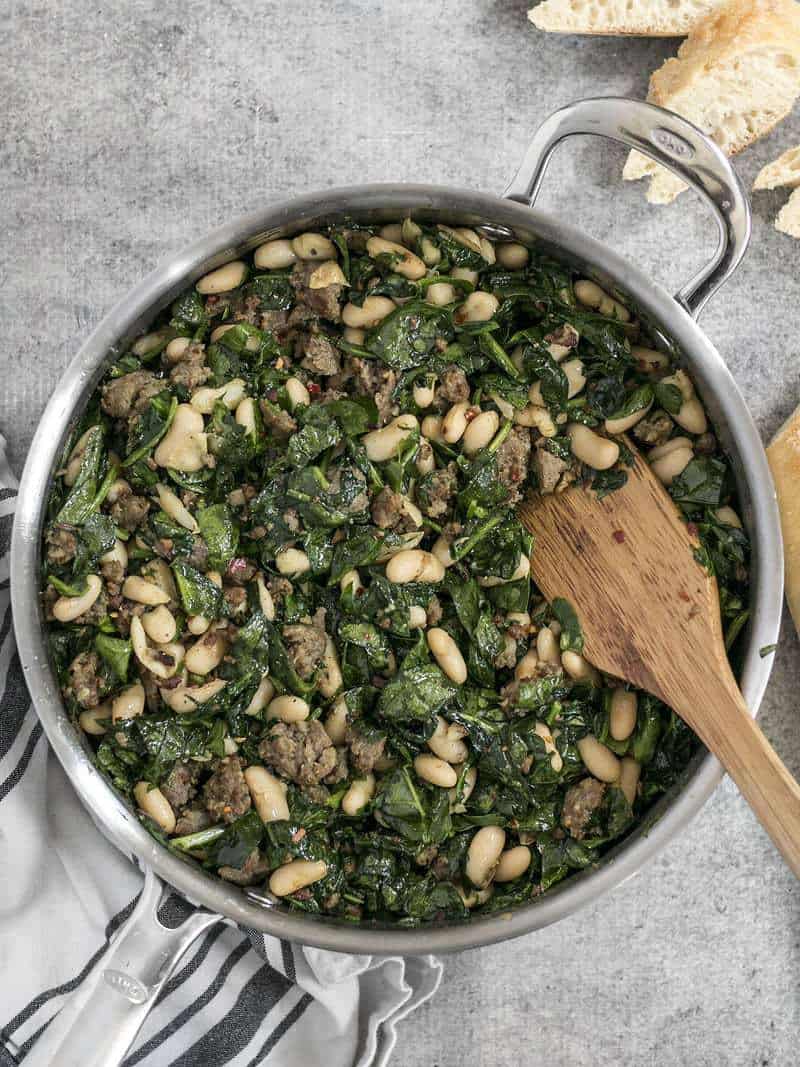 Overhead shot of the Italian Sausage and White Bean Skillet with a wooden spatula