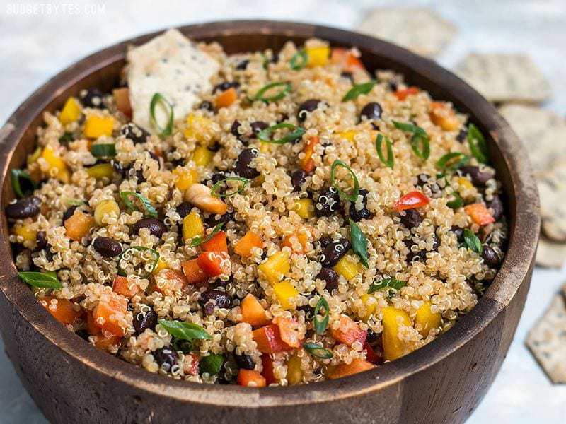 Front view of Smoky Quinoa and Black Bean Salad with a chip dipped in.