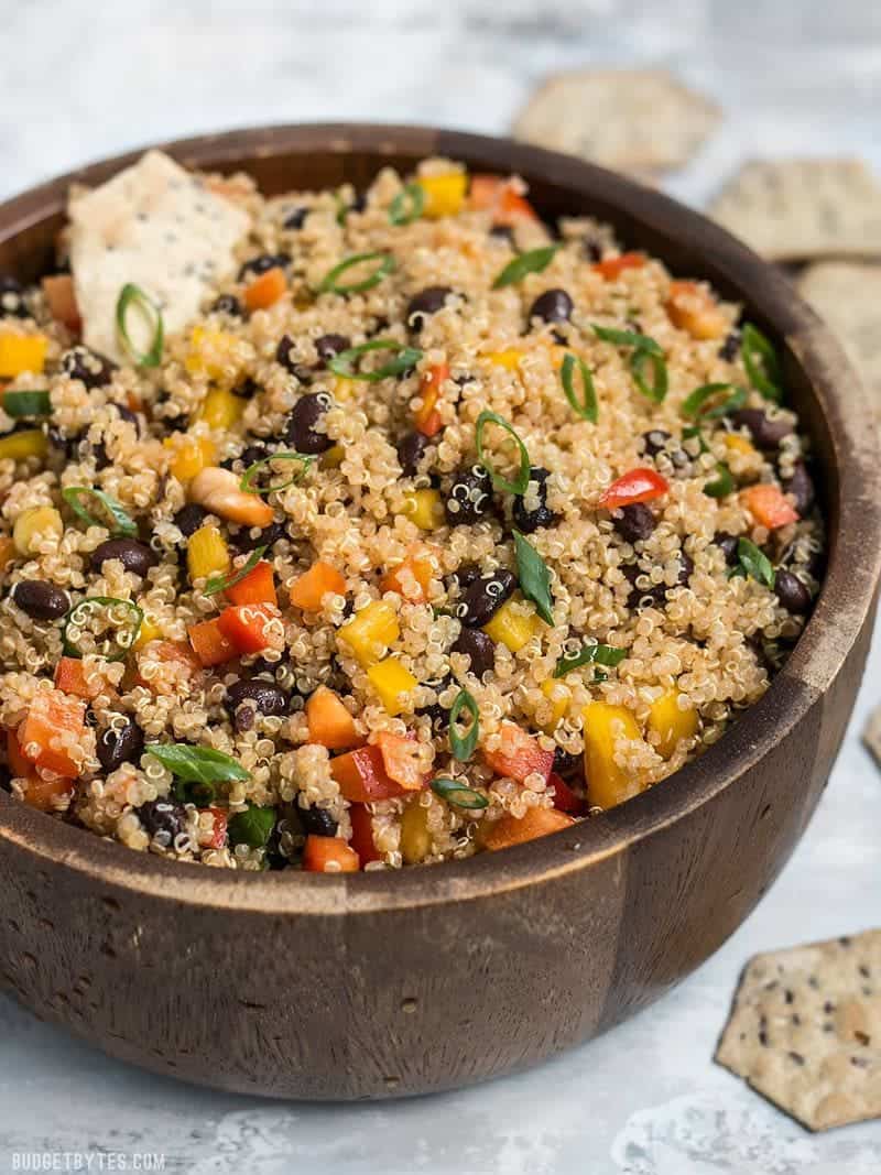 Smoky Quinoa and Black Bean Salad in a wooden bowl with crackers.