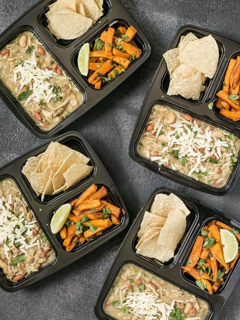 Four White Chicken Chili Meal Prep containers scattered on a surface
