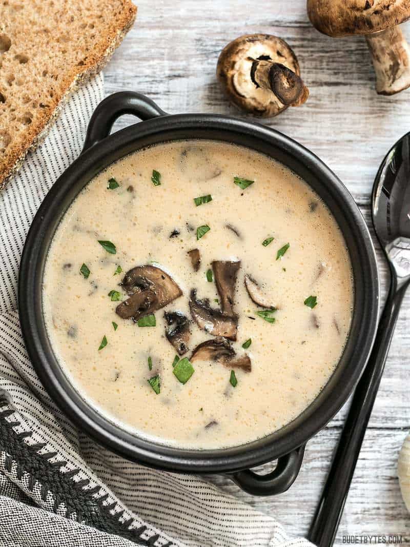 A bowl of Creamy Garlic Mushroom Soup with crusty bread for dipping.