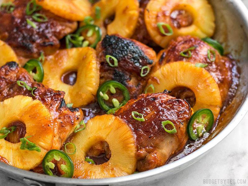 Close up of Skillet Pineapple BBQ Chicken with thick slices of pineapple in skillet.