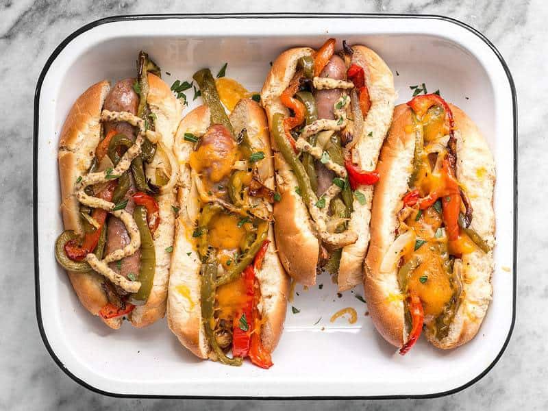 Roasted Bratwurst with Peppers and Onions in a baking dish.