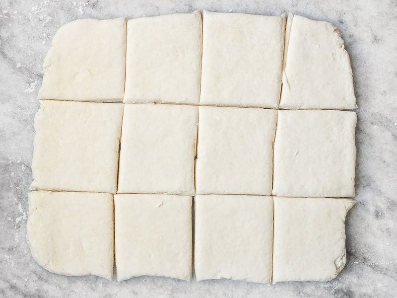 Biscuit dough cut into 12 squares