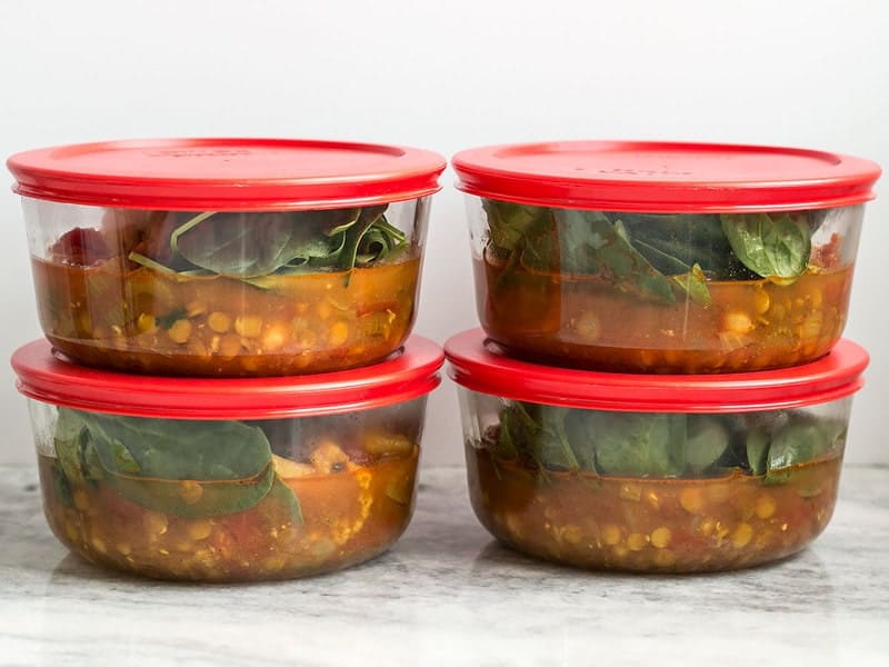 Pyrex round glass containers full of stew, stacked