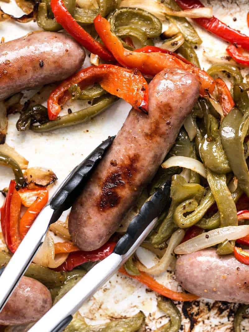 Close up of Roasted Bratwurst with Peppers and Onions on the roasting tray.