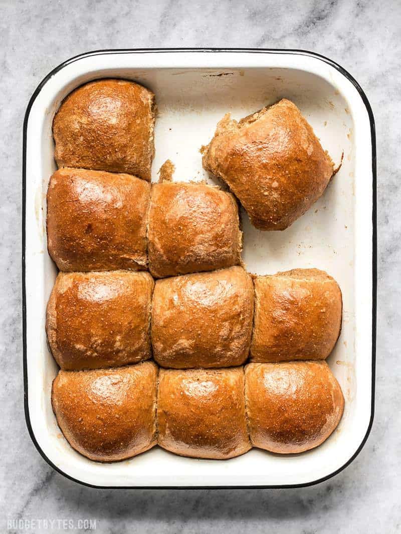 A baking dish with Sweet Molasses Dinner Rolls with a few removed