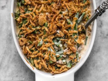 Overhead view of green bean casserole in an oval dish with a spoon