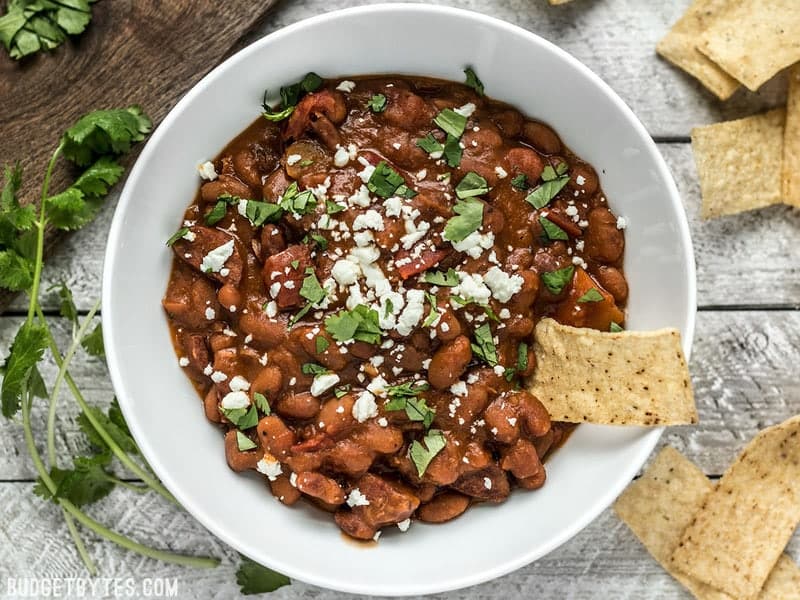 Overhead view of Instant Pot Pinto Beans with Chorizo, topped with cheese and cilantro