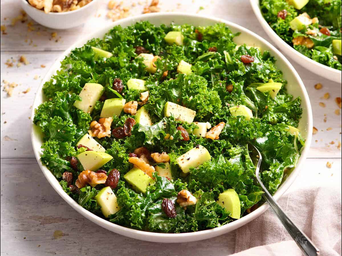 Side view of a kale salad in a bowl.