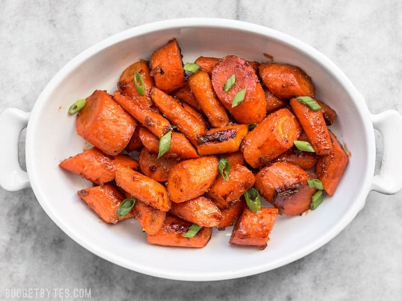 Maple Miso Roasted Carrots in a serving dish with green onions