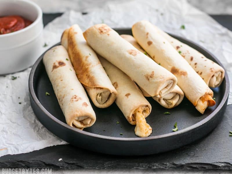 Side view of Pizza Roll Ups on a plate with melted cheese oozing out.