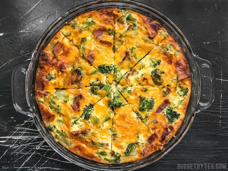 Baked and sliced Bacon Broccoli Cheddar Crustless Quiche in a glass pie plate