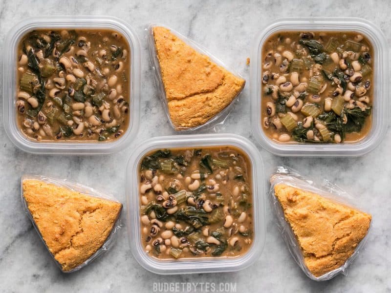 Three Black Eyed Peas Meal Prep containers alternating with cornbread slices