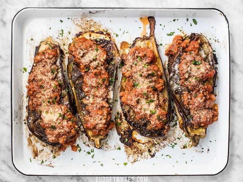 Four Roasted Eggplant with Meat Sauce lined up on a baking sheet