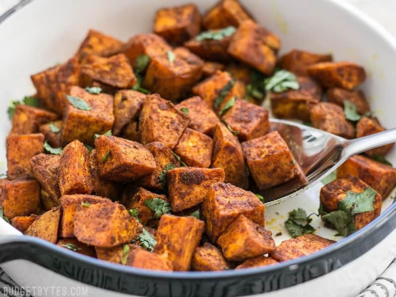 Close up of Moroccan Spiced Sweet Potatoes being scooped out of a dish
