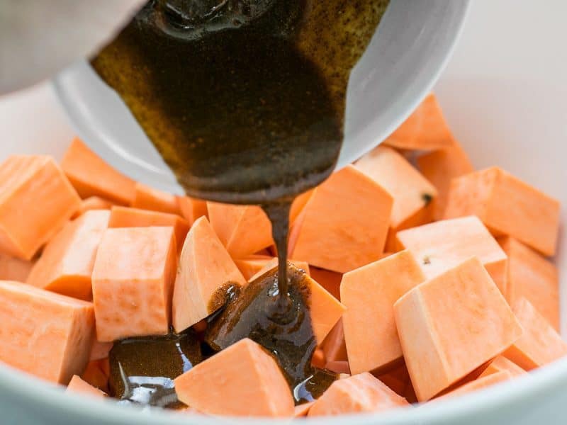 Pour Oil and Spices Over Sweet Potatoes