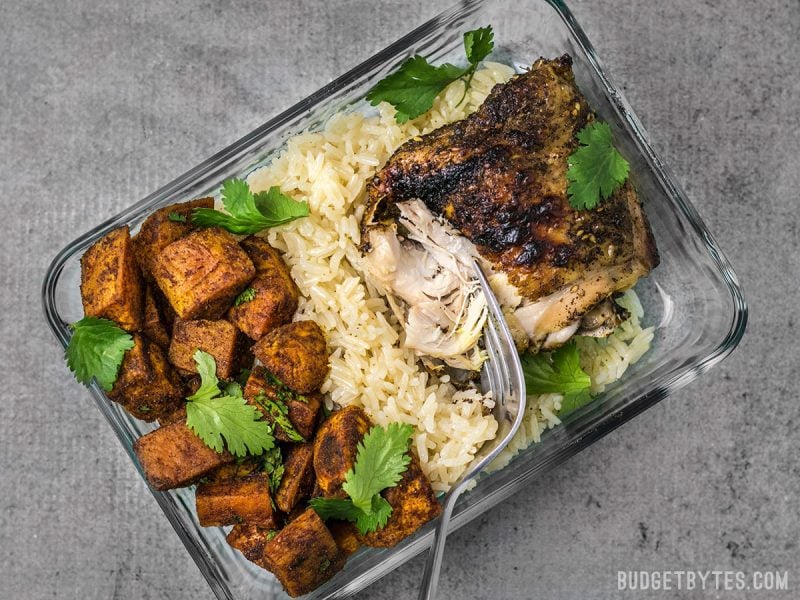 One Pressure Cooker Chicken and Rice Meal container with a fork pulling the chicken
