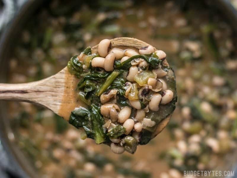 A ladle full of Slow Simmered Black Eyed Peas with Greens