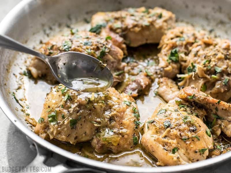 Close up of Herb Butter Chicken Thighs with sauce being drizzled over.