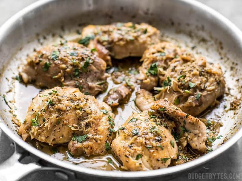 A close up of the herb butter chicken thighs in the skillet just after cooking.