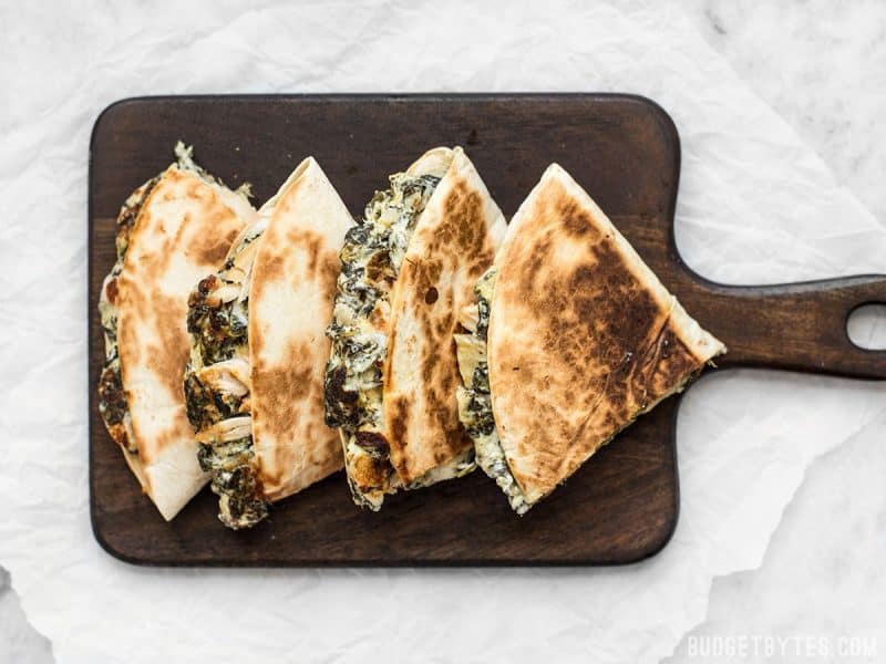Use your leftover party dips to make a delicious lunch the next day, like these super creamy Spinach Artichoke Quesadillas. Budgetbytes.com Overhead view of Spinach Artichoke Quesadillas on a cutting board