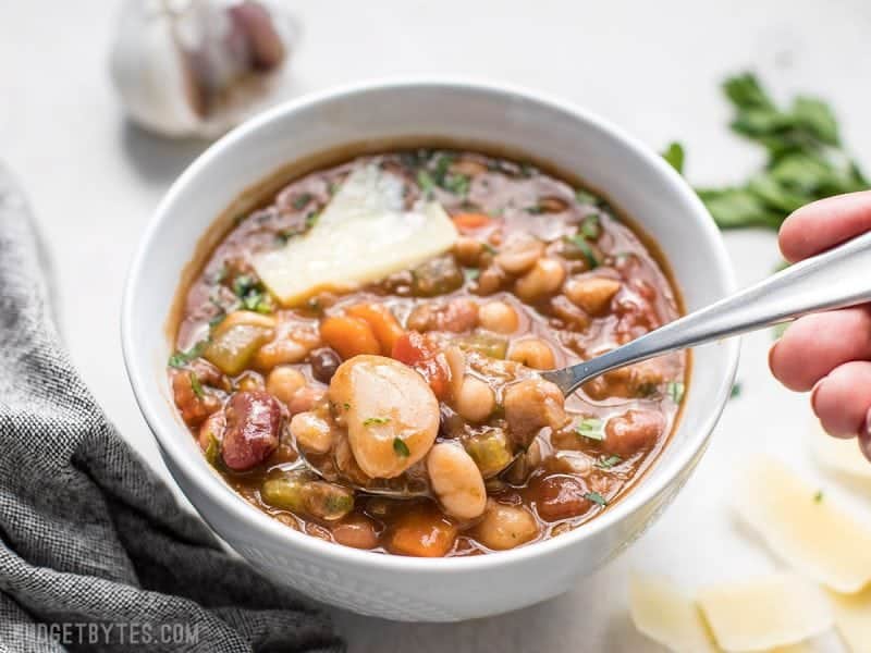 A bowl of 15 Bean Soup being eaten with a spoon.