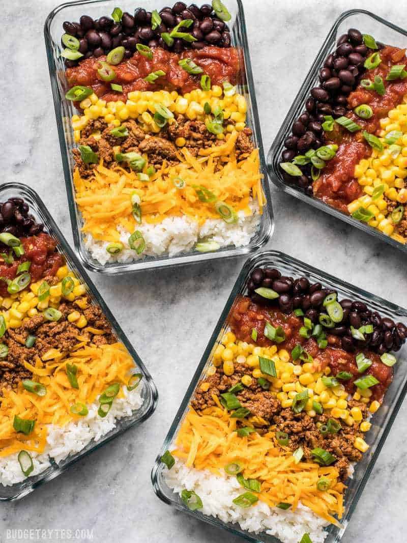 Four Burrito Bowl Meal Prep containers scattered about