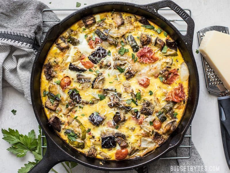 Baked Ratatouille Frittata on cooling rack with Parmesan and grater near by.