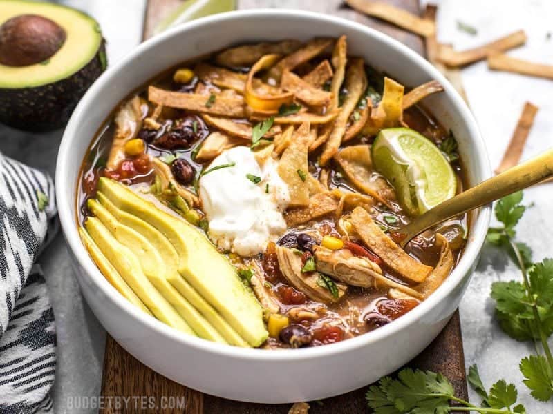 Front view of a bowl of Slow Cooker Chicken Tortilla soup with all the toppings.