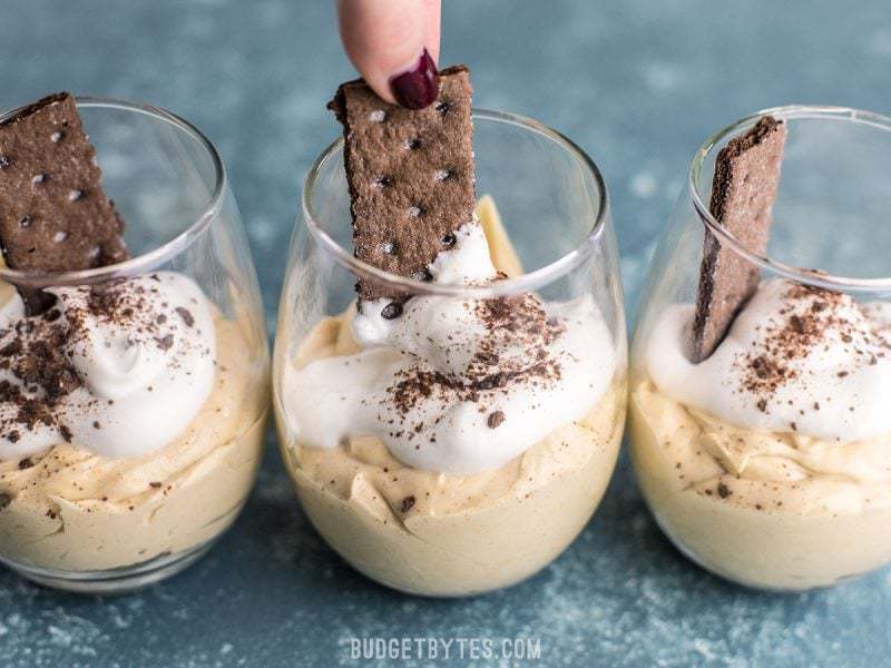 A chocolate graham cracker being pulled from a Peanut Butter Fluff Cup