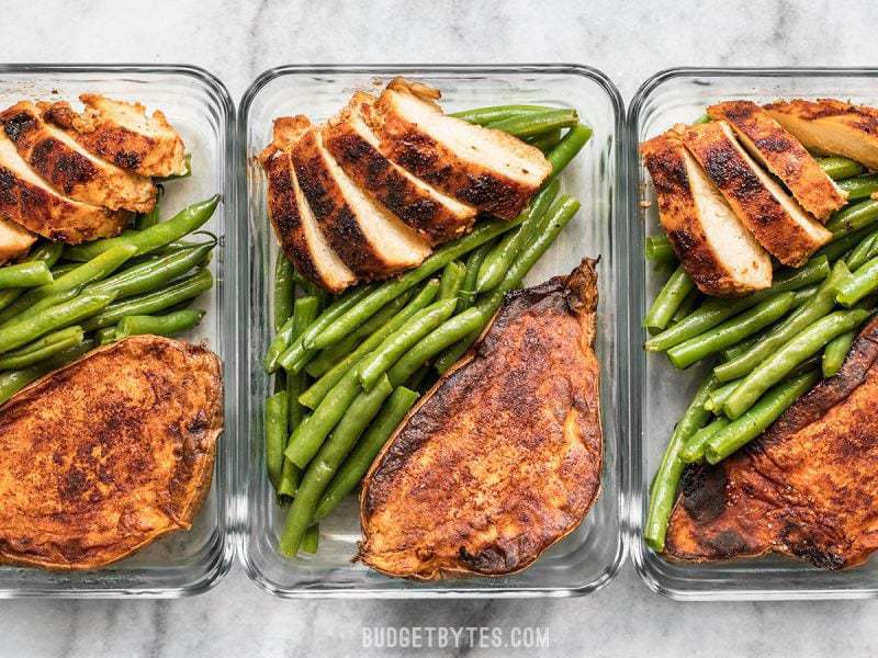 Three glass meal prep containers in a row with Smoky Chicken and Cinnamon Roasted Sweet Potatoes