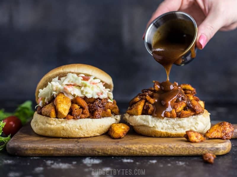 Front view of BBQ sauce being drizzled onto an open BBQ Tofu Slider.